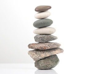 pyramid of stacked stones on a white background. stabilization and balance in life