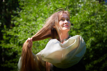 Beautiful dryad or fairy with gorgeous long hair in nature. Environmental friendliness and caring...