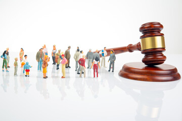 Miniature people. Many people near the gavel of law and justice. Laws to ensure the life of the...