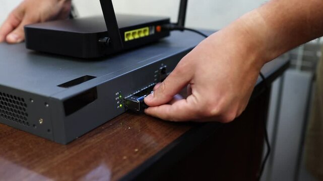 Connecting a router, router to the Internet network via an optical cable - patch cord with an adapter. Operation and reception of a network signal. Equipment for Internet services.