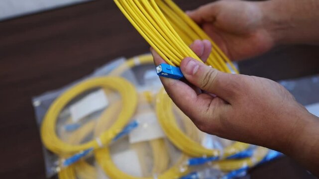 Overview Patch cord (switch cord) in the hands of a man in an engineering room for connecting electronic equipment to each other or for connecting this equipment to communication systems.