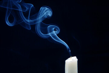 Smoke from an extinguished candle on a dark background. The concept of spirituality and the end of...