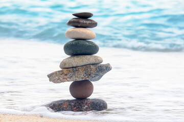 pyramid of stacked stones on the seashore. stabilization and balance in life