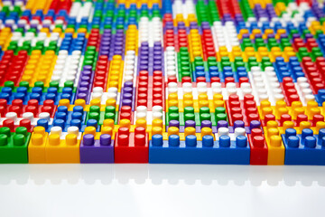 Abstract background texture of colored constructor blocks. Background of colorful plastic part of constructor. Pile of colored toy bricks.