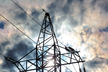 High voltage tower with electrical voltage wires isolates close-up against the background of...