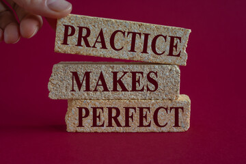 Practice makes perfect symbol. Brick blocks with words Practice makes perfect on beautiful pink...