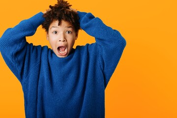 Young woman expresses shock and amazement with hands on head and wideeyed expression in candid...