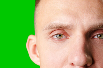 Close-Up Portrait Of A Man With Green Eyes Against A Bright Green Background