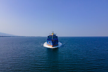 Aerial view in front of cargo ship carrying intermodal cargo containers in sea, concept intermodal logistic service