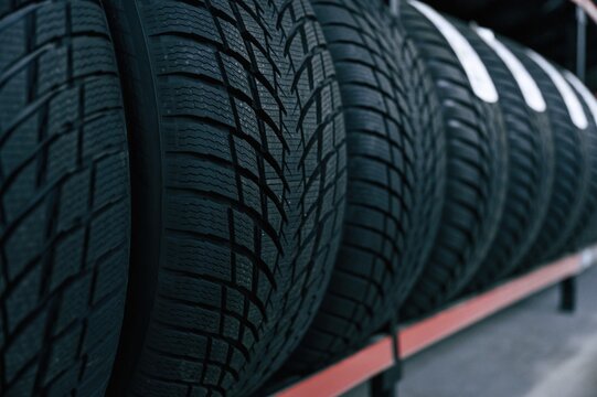 Particle close up view. New tires are placed on the storage rack in the car workshop