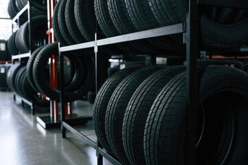 New tires are placed on the storage rack in the car workshop © standret