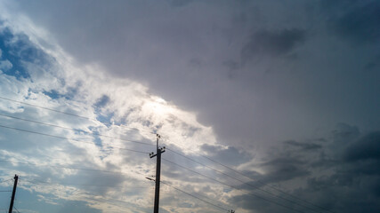 Evening skies with clouds and electric pole with wires