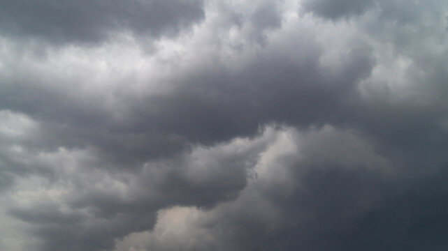 The sky is covered with gray clouds. Gray fluffy rain clouds close-up