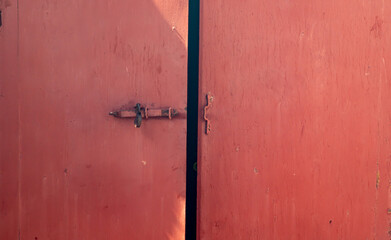 Old red iron door to the garage. Old big red iron door
