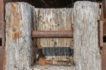 Vintage log timber piece with a rusty metal bar inside, daytime, nobody