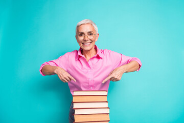 Photo of nice aged woman point finger pile stack book wear pink shirt isolated on teal color background