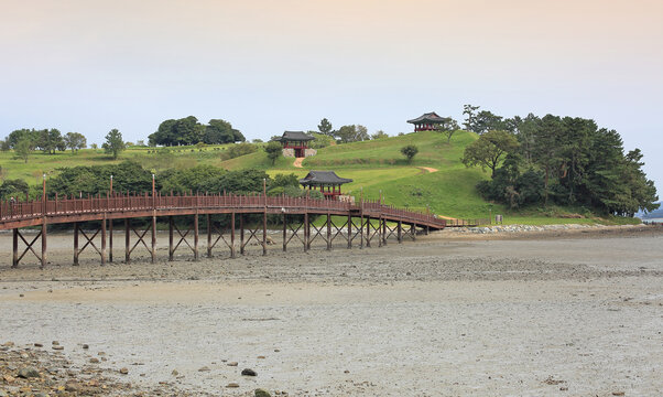Jangdo Island, Wando-gun, Jeollanam-do, South Korea - October 16, 2021: Summer view of wood bridge on mudflat at low tide at Cheonghaejin Historic Site of Wando Island