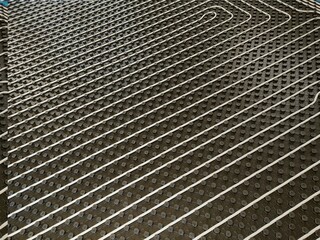 A high-resolution image of the pipes used in a radiant floor heating system, showing the efficient design and even distribution. Perfect for illustrating the benefits of energy-efficient heating solut