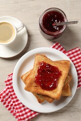 Delicious toasted bread slices served on wooden table, flat lay