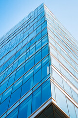 Obraz premium Tall blue skyscraper building under the clear blue sky.