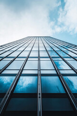 Obraz premium Upward view of a modern glass skyscraper building