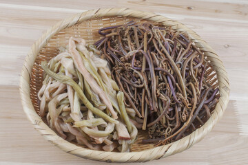 Close-up of boiled taro and bracken stems on a bamboo basket, South Korea