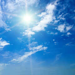 Blue sky with white clouds and sun.