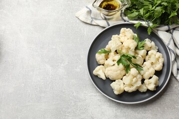 Tasty cauliflower with parsley on grey table, flat lay. Space for text