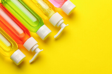 Colorful Bottles of Liquid Soap on Yellow Background