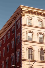 Obraz premium Classic cast-iron architecture white and red building with large, rounded windows in Soho New York on sunny day blue sky