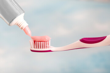 Toothbrush and toothpaste, squeezing toothpaste from tube onto toothbrush close-up. Daily oral care after meals concept.