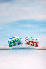 Toothbrush and toothpaste, squeezing toothpaste from tube onto toothbrush close-up. Daily oral care after meals concept.