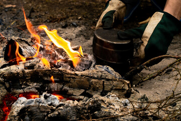 camping cooking on bonfire with in pot