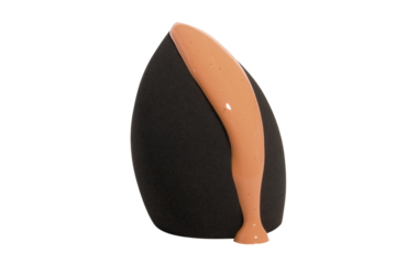 Cosmetic black beauty blender or sponge with a drop of flowing foundation on a blank background.