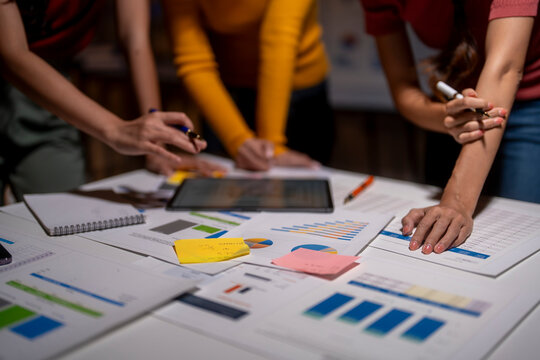 Business team working late, analyzing financial data and brainstorming new ideas