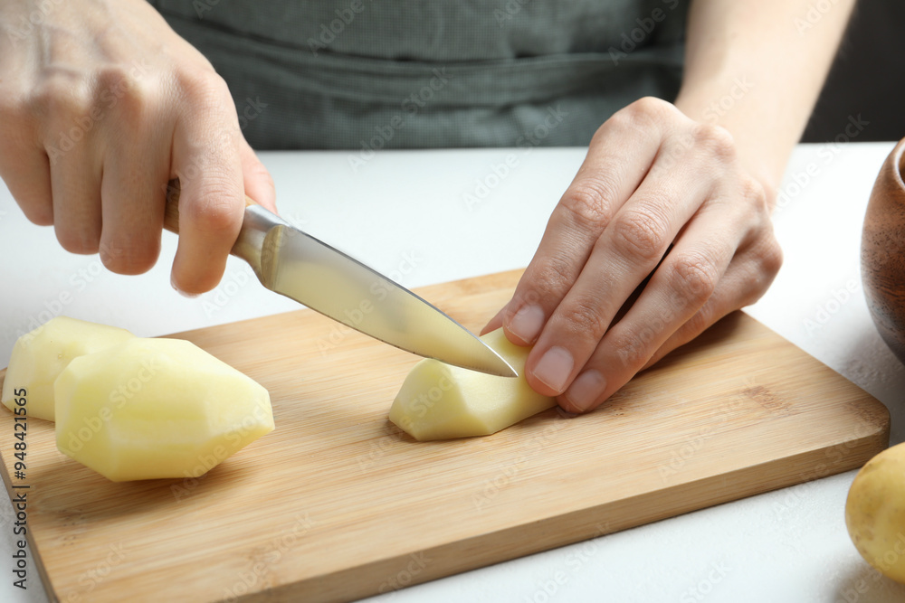 Canvas Prints woman cutting raw potato at white table, closeup