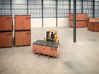 Project cargo in big wooden boxes stored in the warehouse. The cargo in wooden boxes handling by forklift.