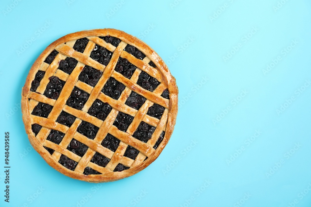 Wall mural Tasty homemade pie with blueberries on light blue table, top view. Space for text