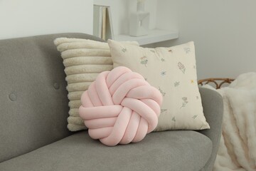 Different soft pillows on sofa in room