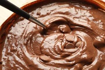 Melting chocolate chips for dough in bowl, closeup