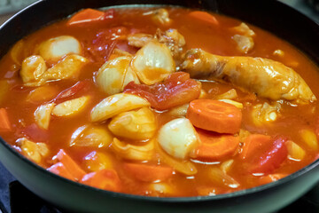 A delicious chicken stew simmering with vegetables in a rich tomato sauce, perfect for a comforting meal.
