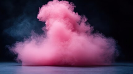 Naklejka premium A plume of pink smoke billows gracefully on a stage against a dark, atmospheric background, creating a mystical and evocative scene enhanced by dramatic lighting.