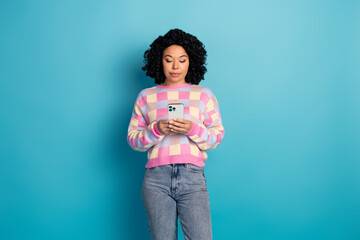 Photo portrait of attractive young woman hold device dressed stylish pink plaid clothes isolated on blue color background