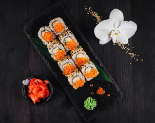 Sushi rolls set served on black stone with ginger and wasabi