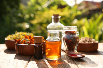 Different tinctures and ingredients on wooden table outdoors