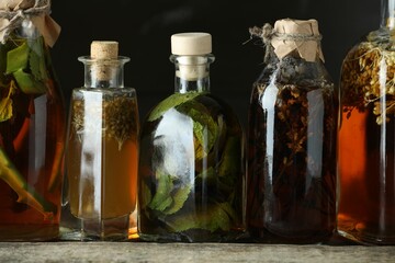 Different tinctures in bottles on wooden table, closeup