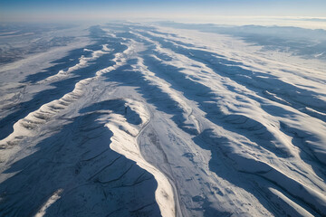 Fototapeta premium a aerial view photo of a smooth, snow-covered plain, with soft undulations providing a clean and peaceful backdrop