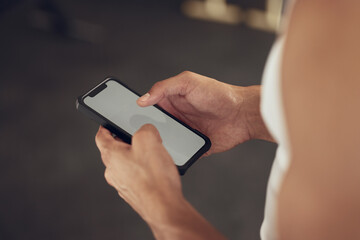 Person, hands and phone with screen at gym for tracking workout progress, exercise app or reading notification. Athlete, fitness and smartphone at sports club for training website and wellness tips
