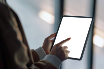 Close up of person hands using digital table with screen in black backdrop for copy space