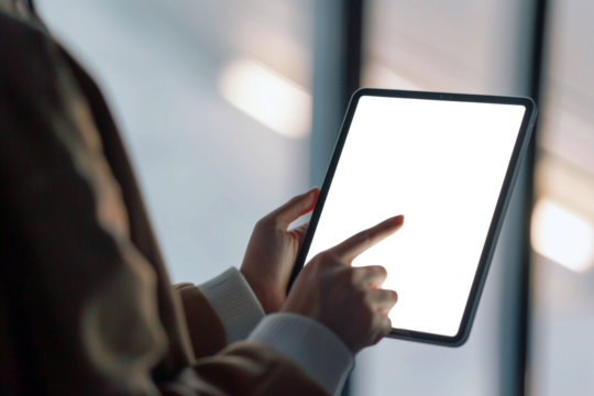 Close up of person hands using digital table with screen in black backdrop for copy space